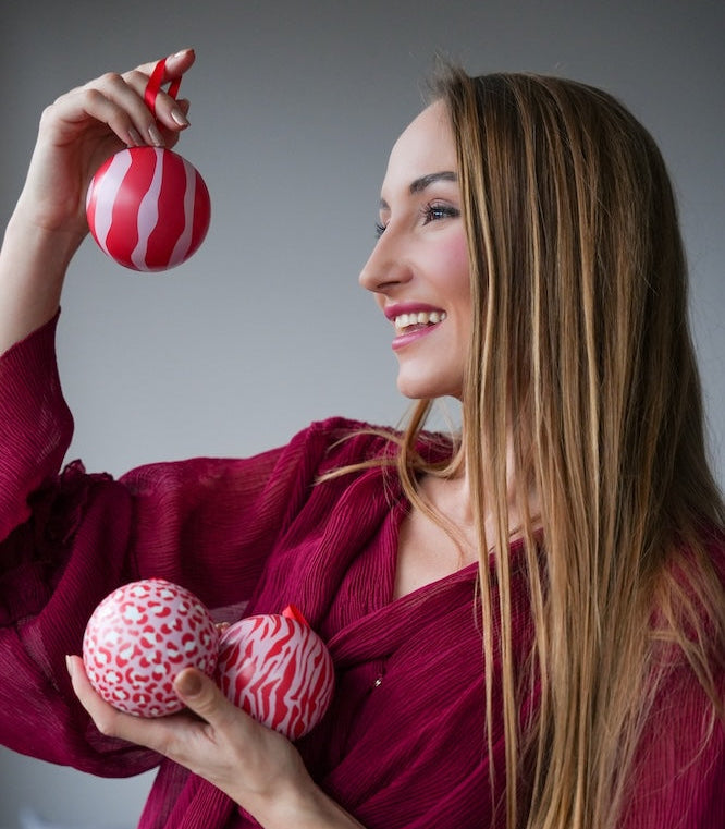 Woman holding decorative eggs against a gray background